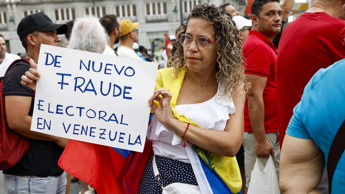 Una mujer sostiene una pancarta en la manifestación convocada por la oposición venezolana un día después de las elecciones en el país, este lunes en Madrid.