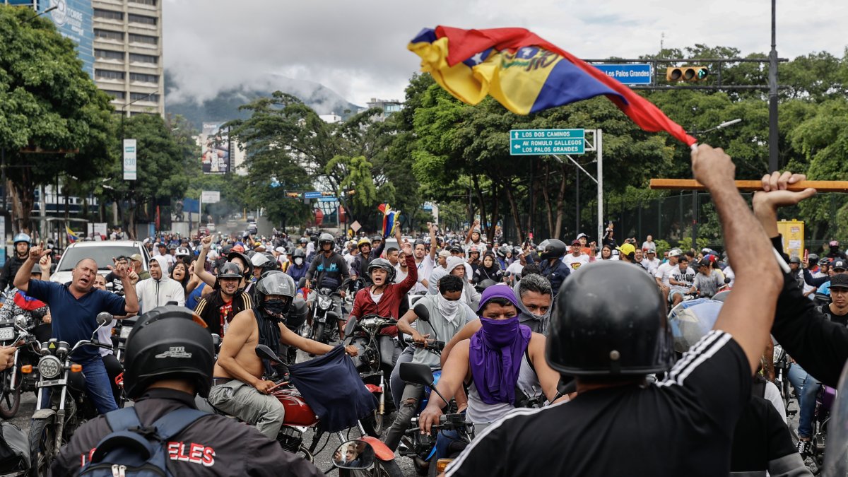 Opositores al gobierno de Nicolás Maduro recorren las calles en motocicletas.