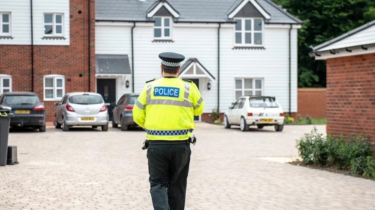 Un agente de policía patrulla por una calle de Amesury, Reino Unido.