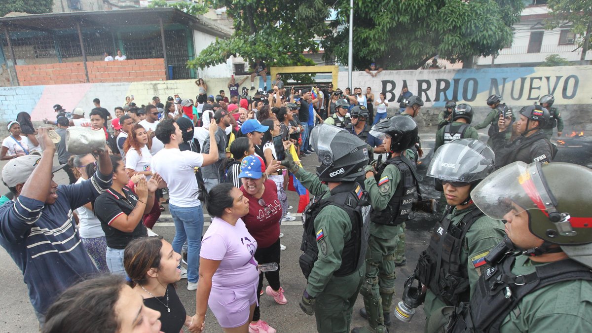 Personas reclaman frente a integrantes de la Guardia Nacional Bolivariana (GNB) durante una manifestación en Caracas.