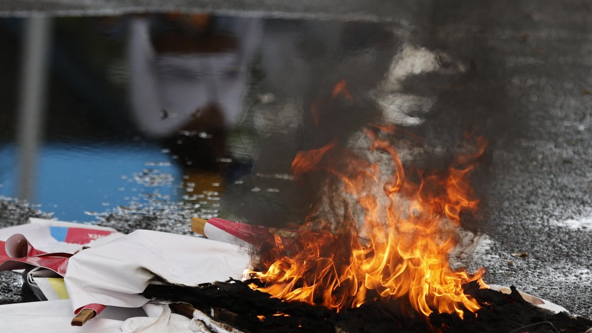 Fotografía de un cartel en llamas durante una protesta por los resultados de las elecciones presidenciales este lunes, en Caracas (Venezuela).