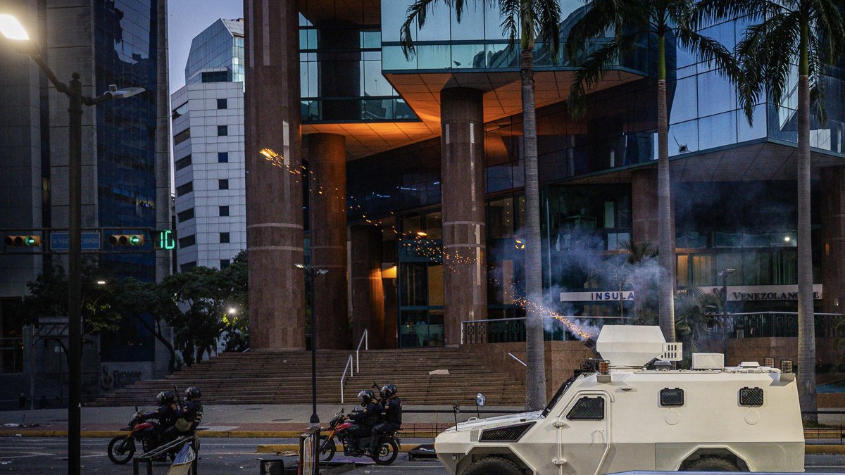 Integrantes de la Guardia Nacional Bolivariana (GNB) se enfrentan a manifestantes por los resultados de las elecciones presidenciales este lunes, en Caracas (Venezuela).