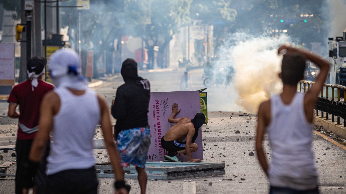 Manifestantes se enfrentan a la Guardia Nacional Bolivariana (GNB), por los resultados de las elecciones presidenciales este lunes, en Caracas (Venezuela).
