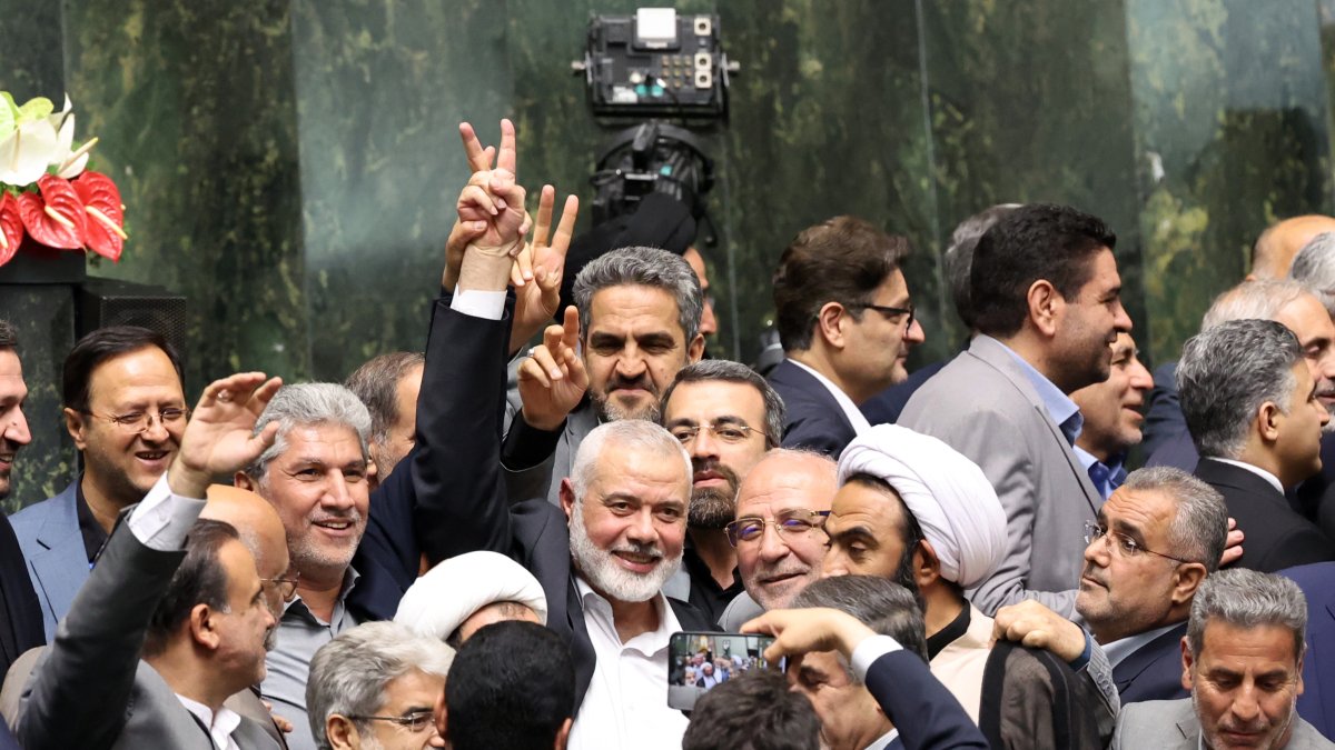 Líder de Hamás, Ismail Haniyeh, (C), en la que hace el signo de la victoria rodeado de legisladores iraníes.