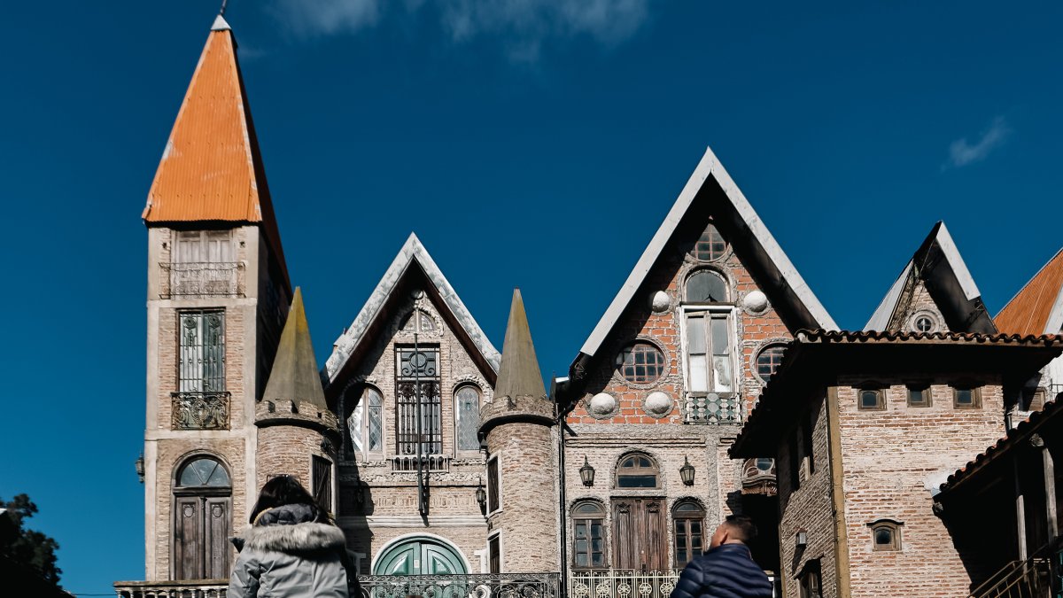 Personas observan las construcciones del asentamiento 'medieval' en el municipio bonaerense de La Matanza.