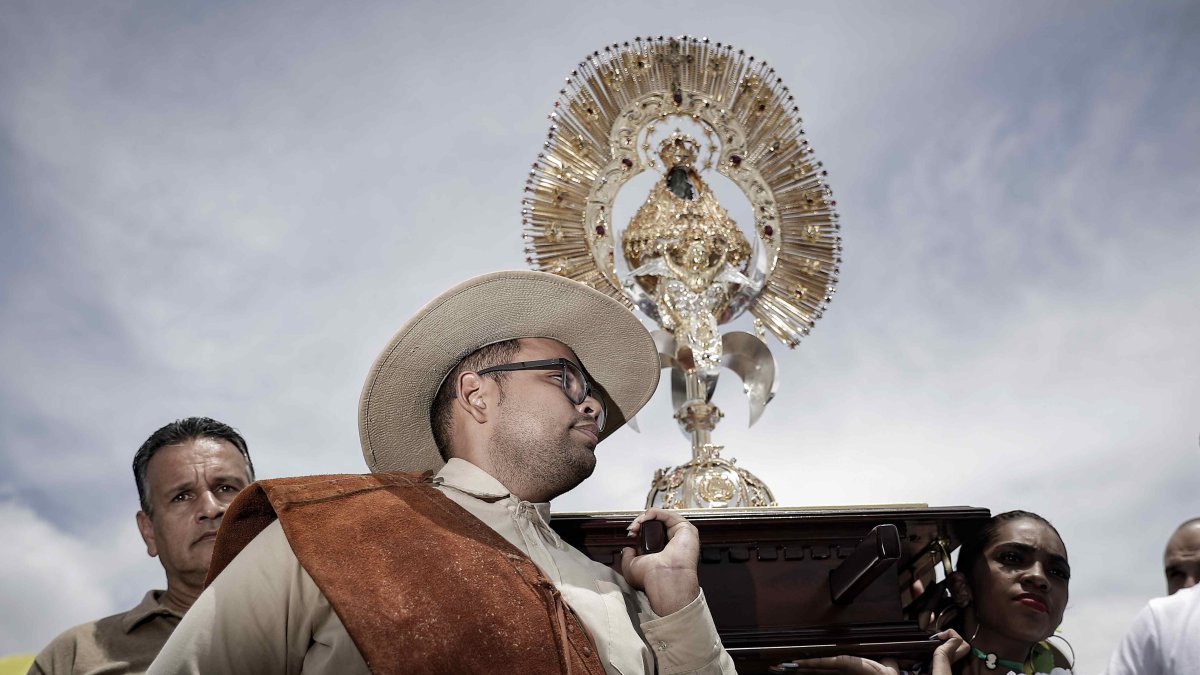 Varias personas participan durante la tradicional romería anual para mostrar su devoción, agradecer milagros y pedir favores a la Virgen de los Ángeles.
