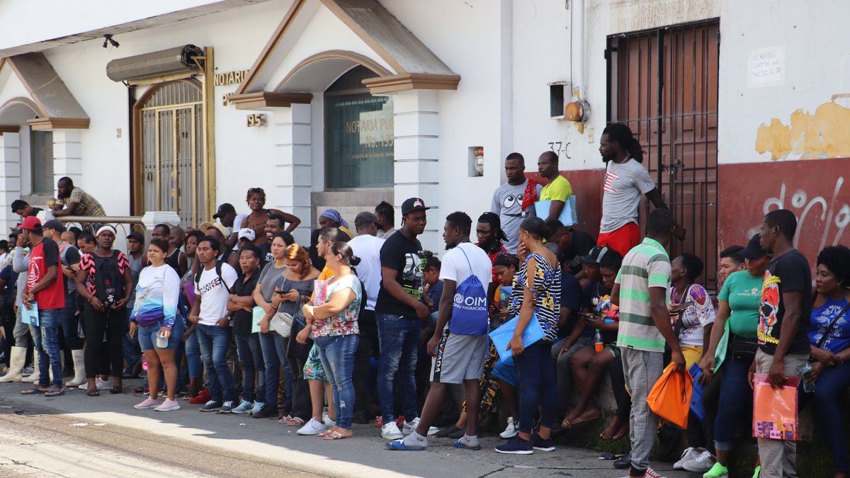 Migrantes hacen fila a la esperar de resolver su situación migratoria este sábado, en la ciudad de Tapachula
