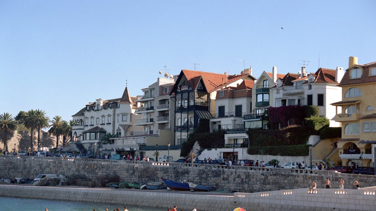 Los bañistas aparecen en la playa de la Ribera en la bahía de los pescadores de Cascais.