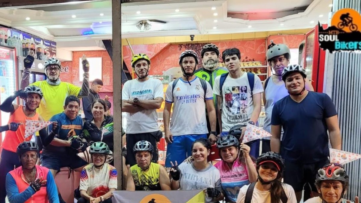 Ciclistas con la bandera en homenaje a Richard Carapaz.