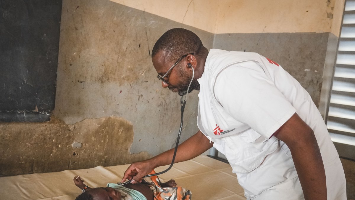 El doctor Baricomo Karambé, médico clínico, se encuentra en medio de una consulta con un niño desplazado.