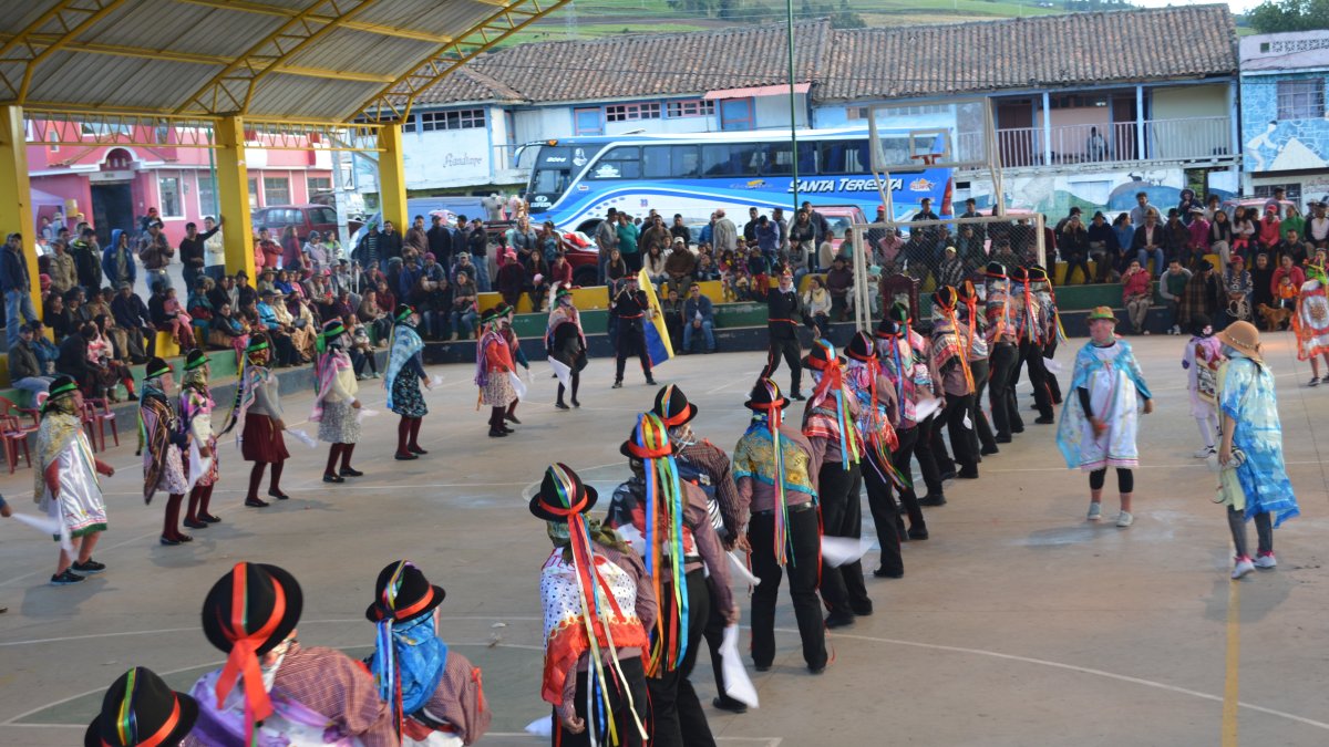 Grupos de hombres y mujeres aparecen en medio de un coliseo disfrazados para representar la danza que da identidad a San José de Poaló.