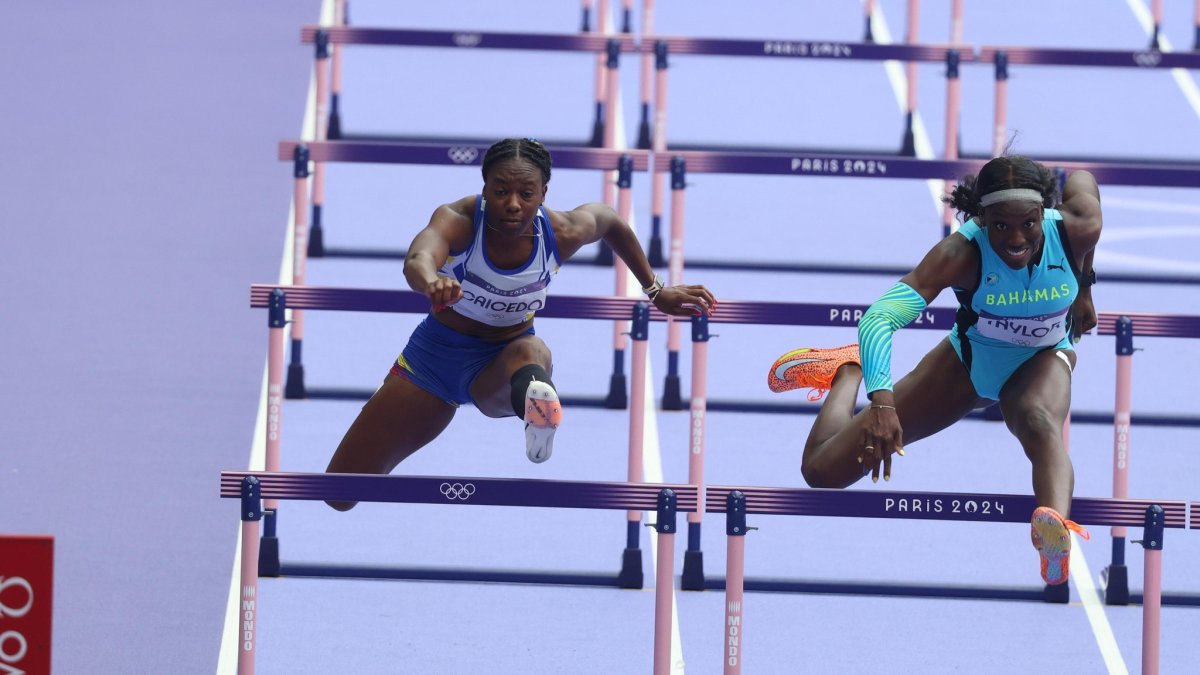 La ecuatoriana Maribel Caicedo (i) junto a Charisma Taylor de Bahamas en semifinales de 100 metros vallas