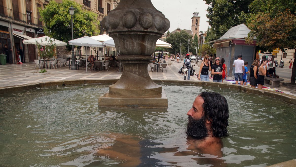 Granada. Un hombre se refresca en una fuente de la Plaza Nueva.