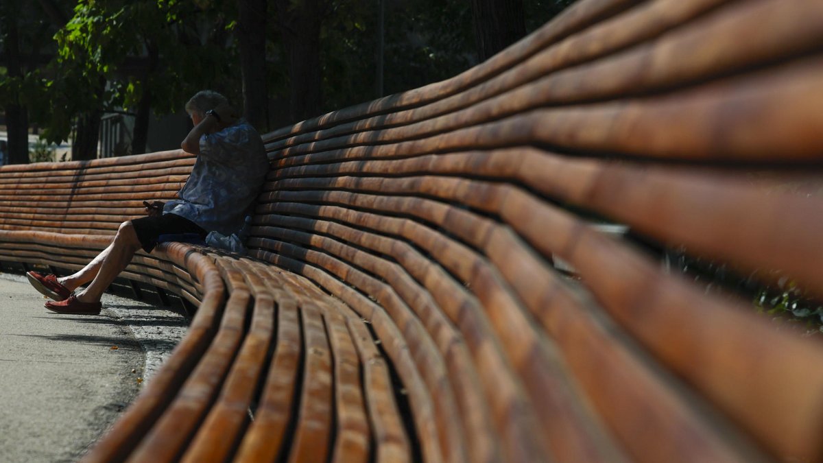 Un hombre busca sombra en un parque de Madrid ante las altas temperaturas.