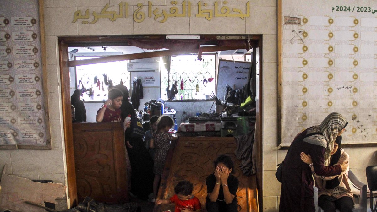 Varios palestinos lloran tras un ataque israelí contra la escuela Al-Taba'een en el barrio de Daraj Tuffah.