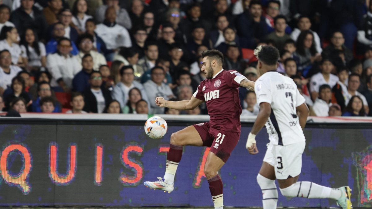 Richard Mina (d) de LDU disputa un balón con Eduardo Salvio de Lanús en el partido de ida de octavos de final de la Copa Sudamericana.