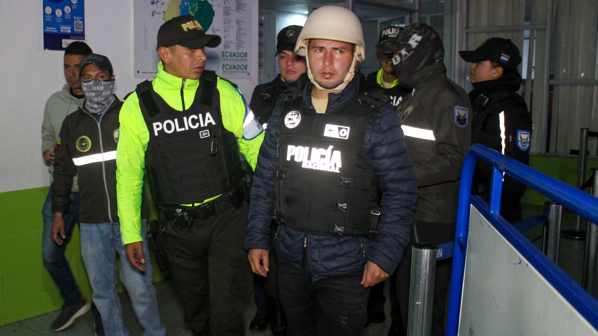 El presunto guerrillero Edgar Moncada Acevedo (d) es escoltado por integrantes de la Policía ecuatoriana.