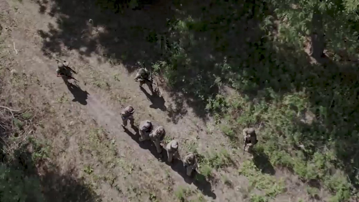 Militares rusos escoltando a prisioneros de guerra ucranianos en un lugar no revelado en la región de Kursk, Rusia.