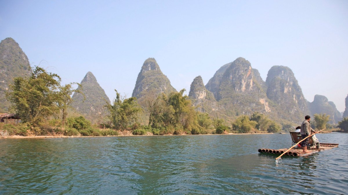 Escenario. Un balsero en un tramo del río Li a su paso por Yangshuo, al sureste de China.