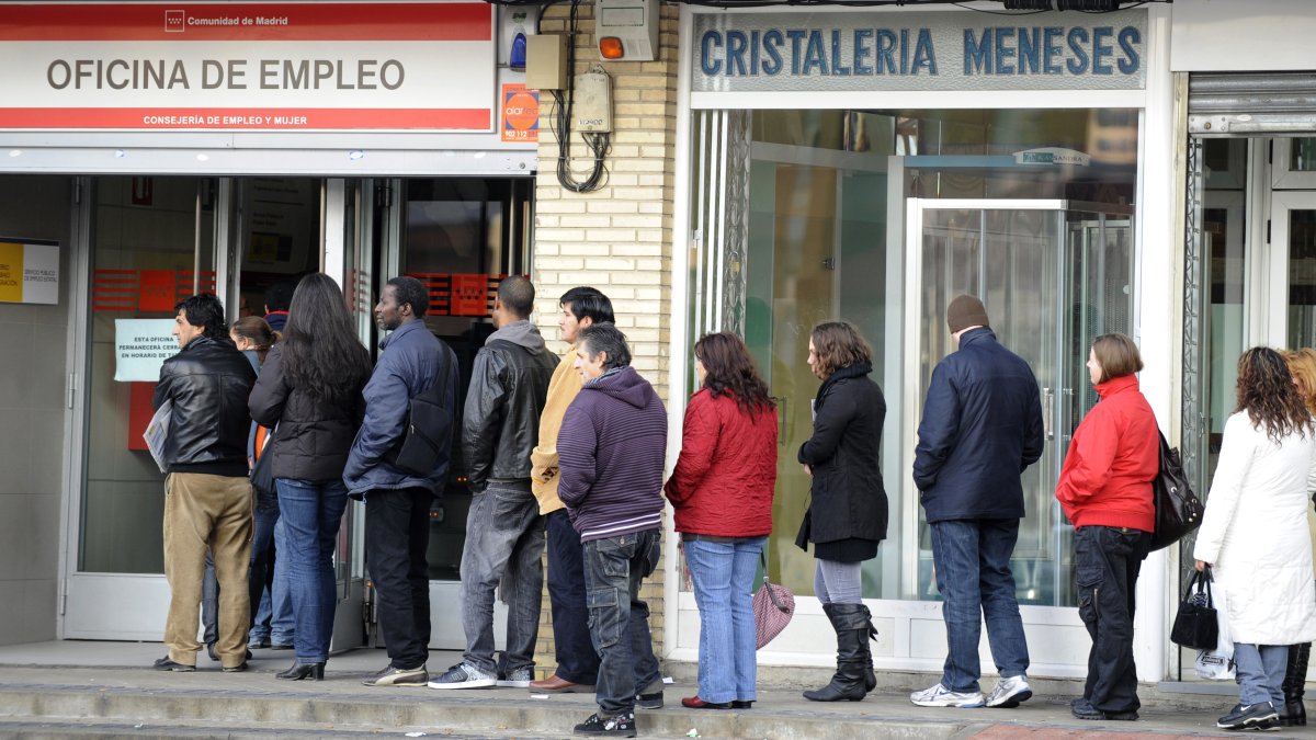 Trabajadores. Una fila de personas que buscan empleo esperan su turno de atención en una oficina en España.