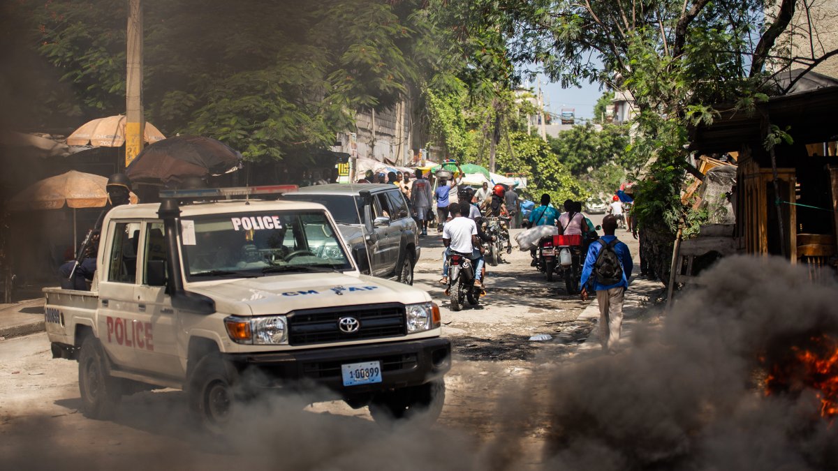 Integrantes de la policía haitiana patrullan durante una protesta, en el barrio Solino en Puerto Príncipe (Haití).