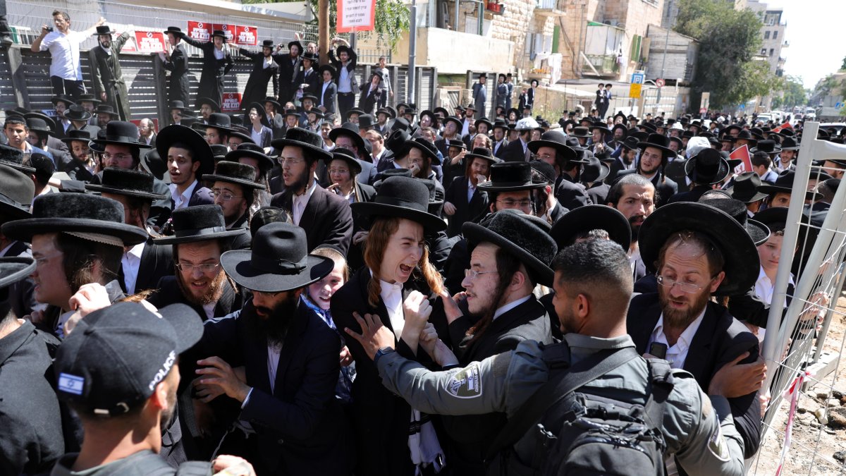 La policía intenta dispersar a judíos ultraortodoxos durante una protesta contra la ley de reclutamiento militar frente a la oficina de reclutamiento en Jerusalén.