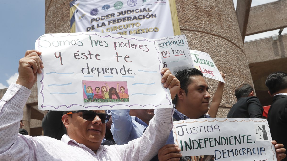 Trabajadores del Poder Judicial que sostienen carteles durante una protesta en contra de la reforma judicial impulsada por el oficialismo, en Ciudad de México (México).