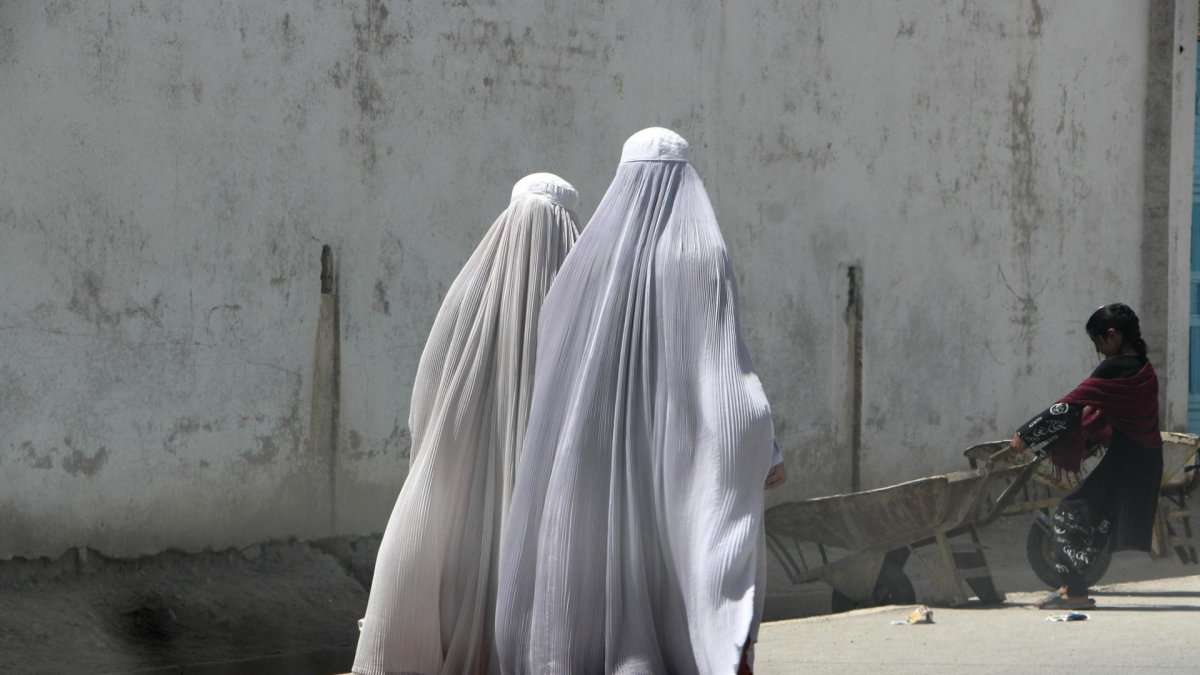 Mujeres afganas vestidas con burka caminan por una carretera en Kandahar.