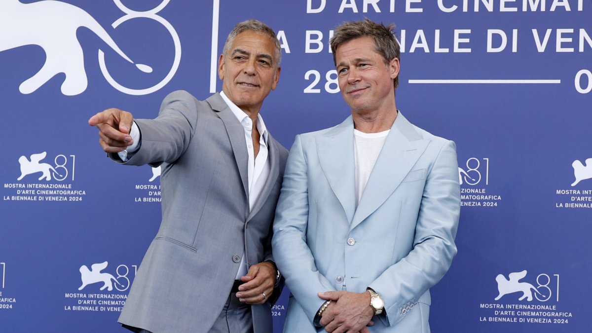 Los actores George Clooney y Brad Pitt posan ante la prensa del Festival de Venecia en la promoción de su película Wolf