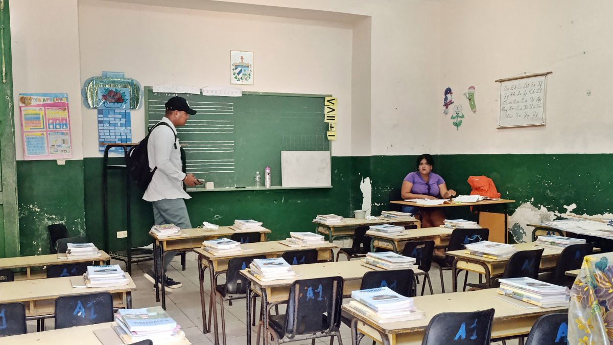 Una profesora prepara clase en el salón de una escuela previo al inicio de clases