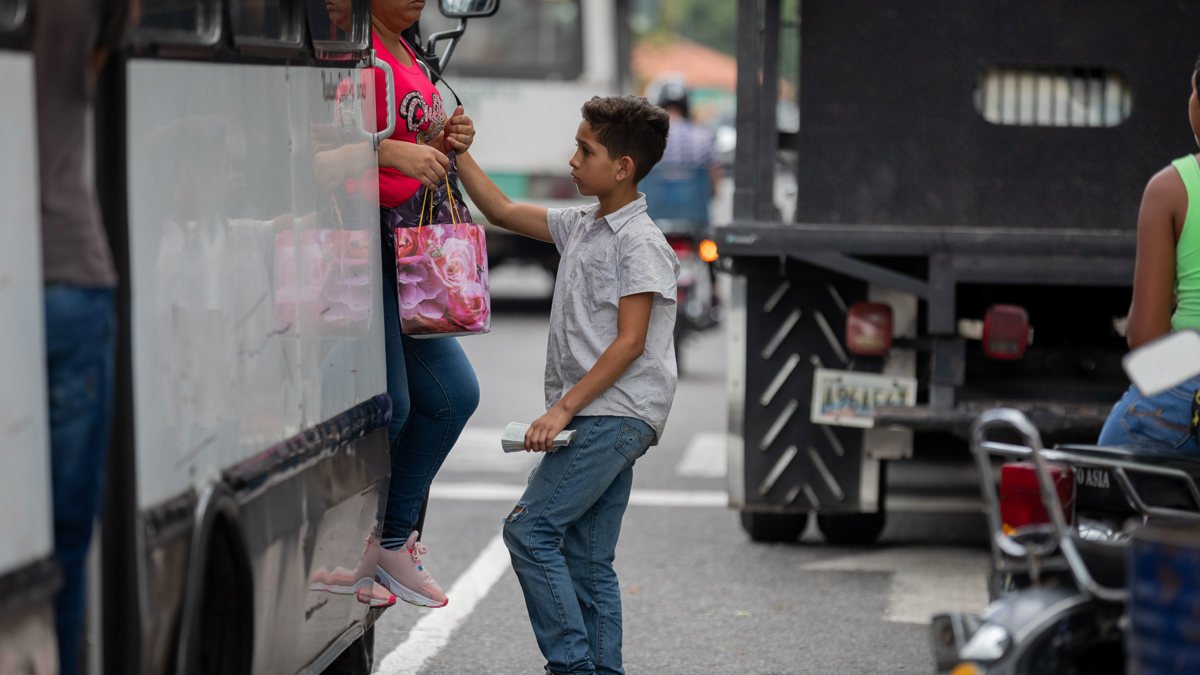 Archivo. Un niño que trabaja en el cobro de los pasajes.