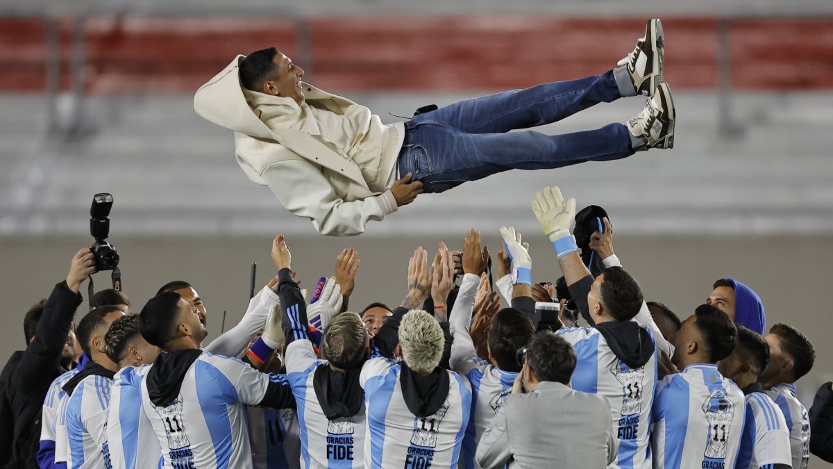 Jugadores de Argentina lanzan a Ángel di María (arriba), previo a un partido de las eliminatorias sudamericana entre Argentina y Chile en el estadio Más Monumental en Buenos Aires 