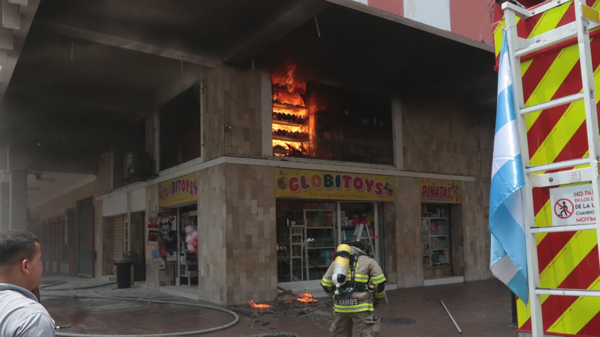 Un bombero intenta sofocar las llamas del interior de un establecimiento en las calles Boyacá y Clemente Ballén, en el centro de Guayaquil.