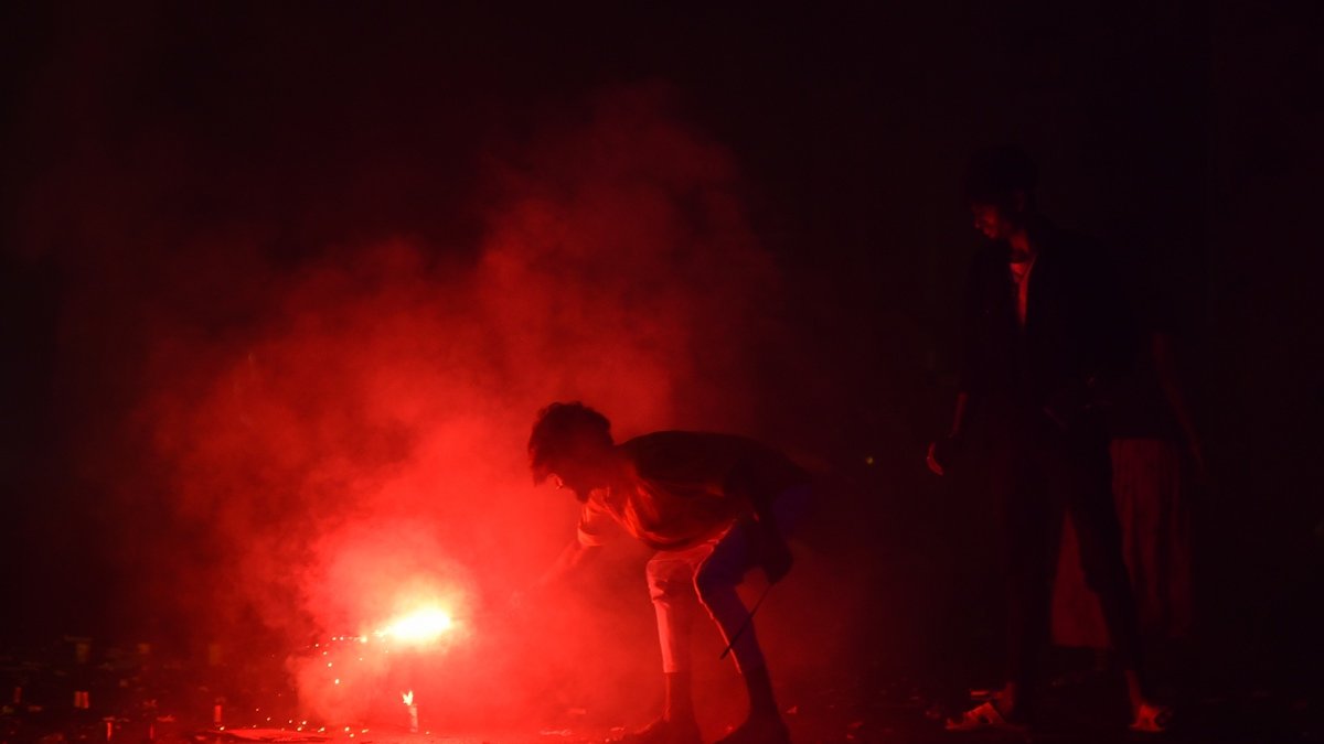 Un niño indio enciende un petardo durante las celebraciones del festival Diwali.