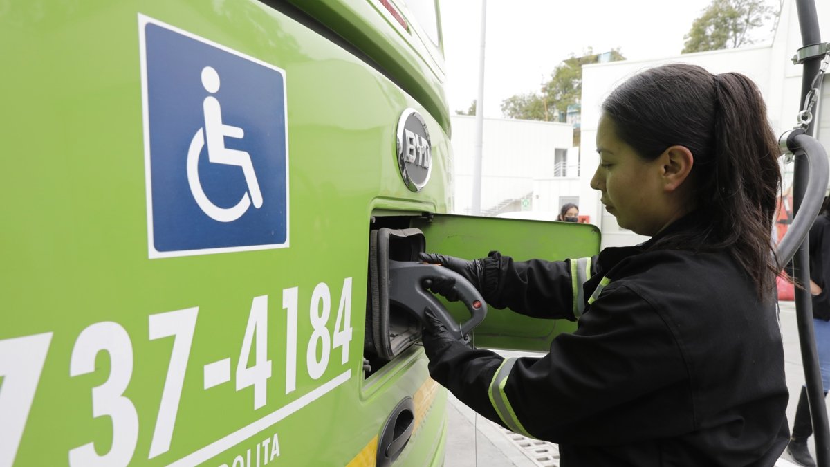 María Camila Escobar, técnica de mantenimiento, cargando un bus eléctrico en Bogotá.