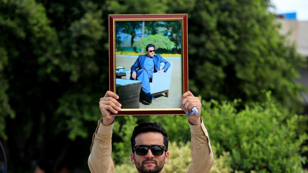 Un partidario del partido Pakistan Tehreek-e-Insaf (PTI) sostiene un retrato del fundador del partido y ex primer ministro Imran Khan.