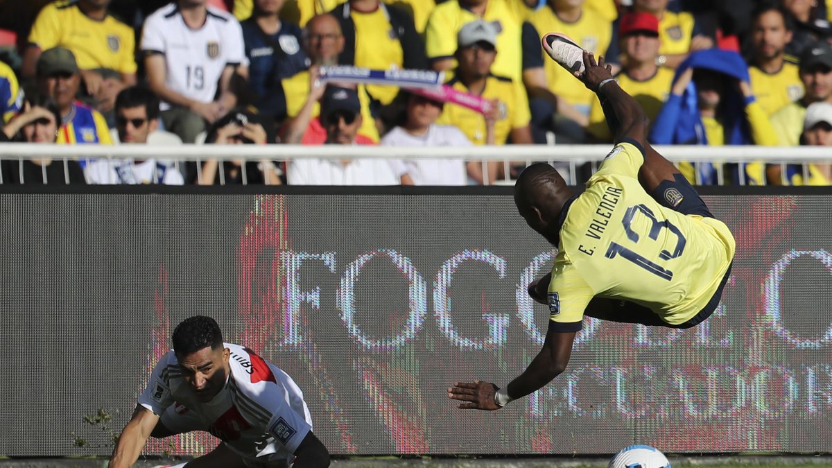 Enner Valencia (d) de Ecuador disputa un balón con Marcos López de Perú este martes.