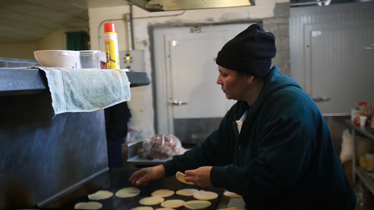 Una mujer hispana trabajando en un local de comida.