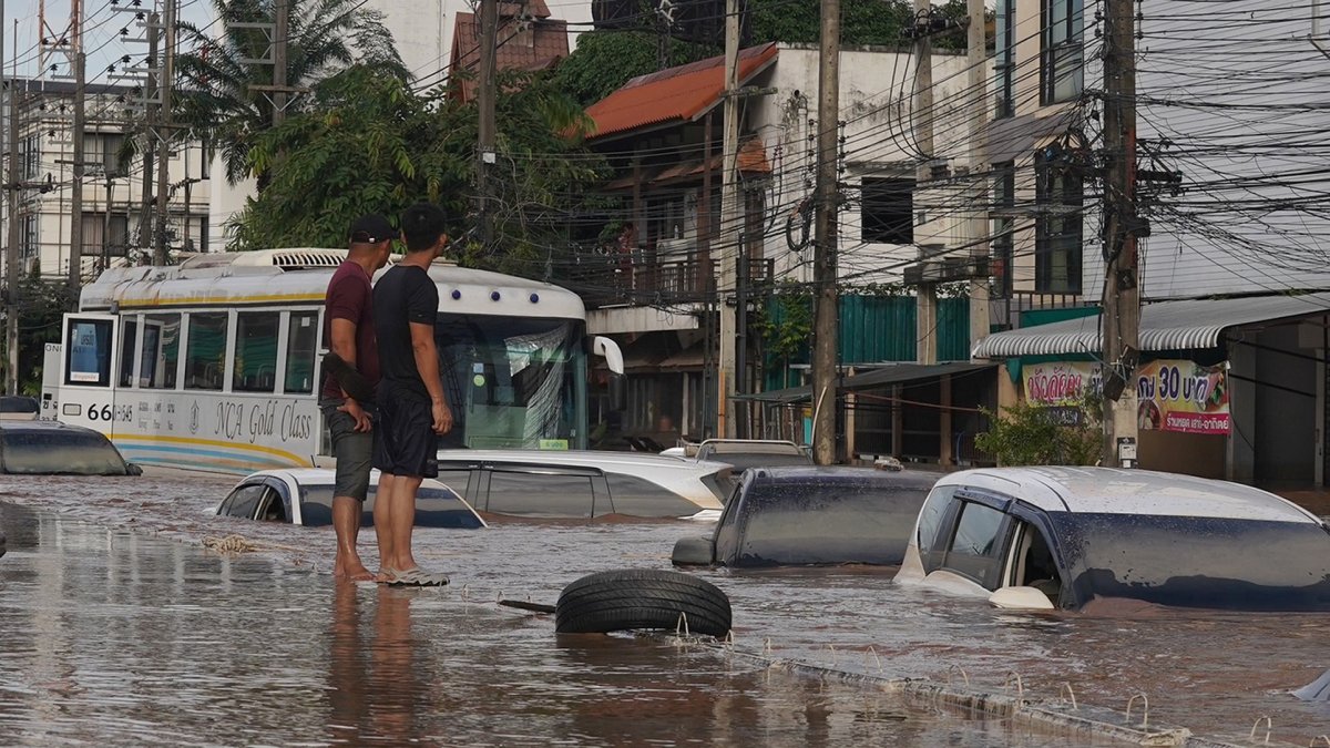 Hombres tailandeses observan una calle inundada tras fuertes lluvias en zonas urbanas de la provincia de Chiang Rai, al norte de Tailandia, el 12 de septiembre de 2024.