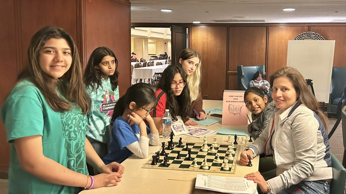 Martha Fierro (der) haciendo lo que más le gusta, enseñando ajedrez.