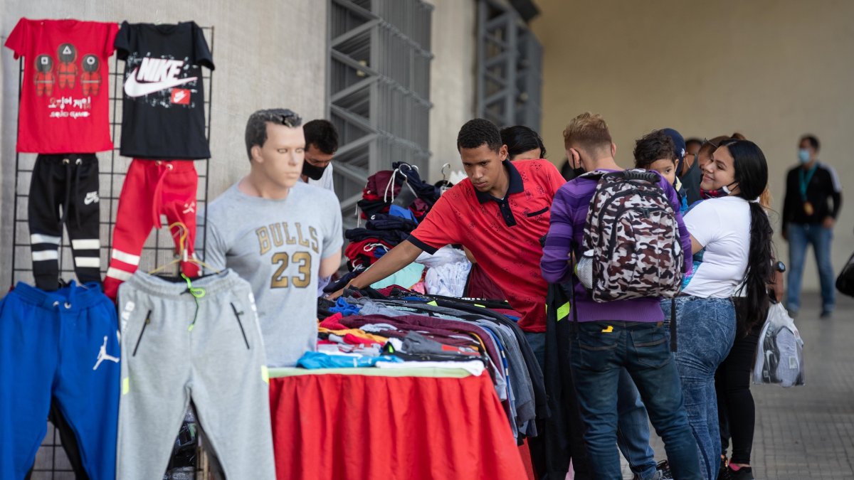 Un vendedor atienda clientes en su puesto de ropa, en Caracas (Venezuela).
