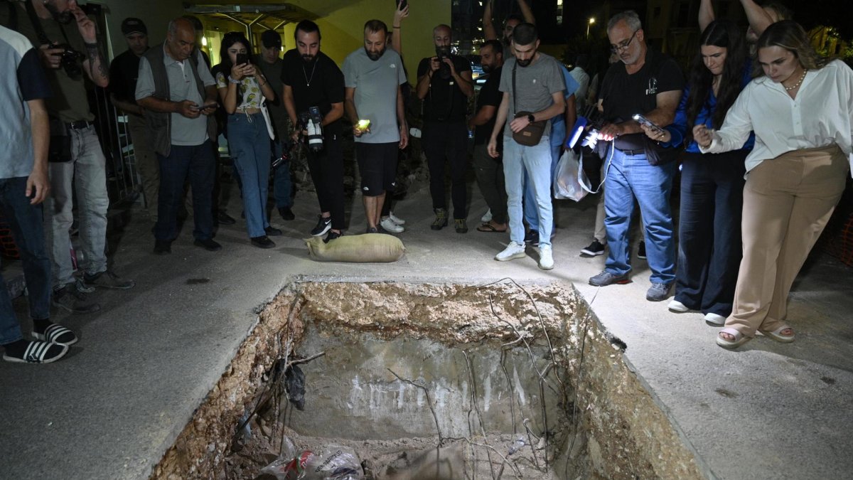 La gente observa hueco donde soldados del ejército libanés hicieran estallar un dispositivo de comunicación, en Beirut.