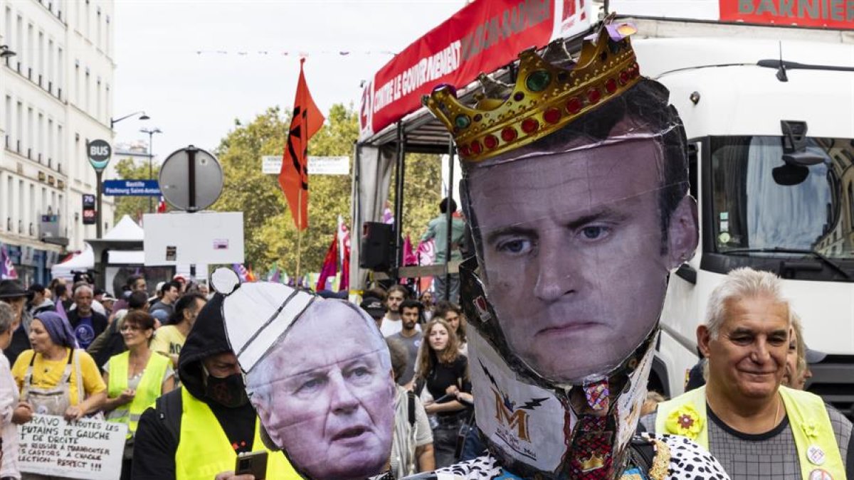 Manifestantes sostienen un cartel del primer ministro Michel Barnier y del presidente francés Emmanuel Macron durante una protesta en París, este sábado 21 de septiembre.