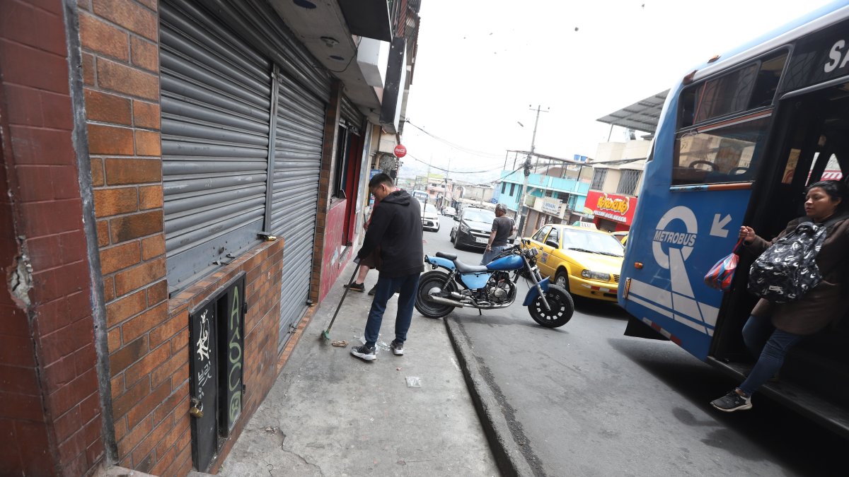impieza. Vecinos limpiaban los vidrios rotos de la peluquería que quedaron esparcidos por la calle tras el violento ataque armado.