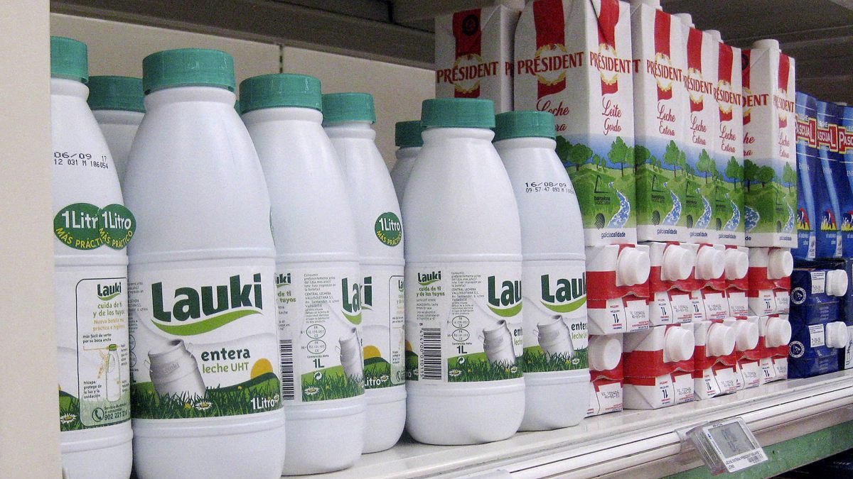 Botellas de leche en envases de plástico en un supermercado