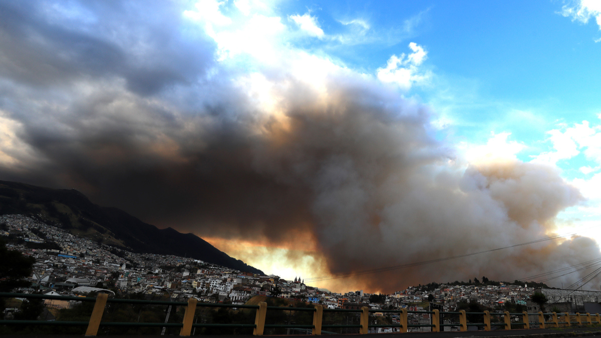 Fotografía de una columna de humo por un incendio forestal este martes, en el sector de Guapulo en Quito (Ecuador).
