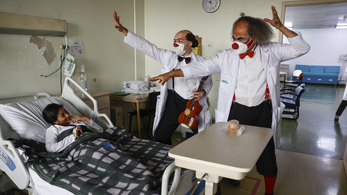 Los payasos Waldisney (i) y Sandoval (d) visitan a un paciente en el Hospital Universitario de São Paulo.