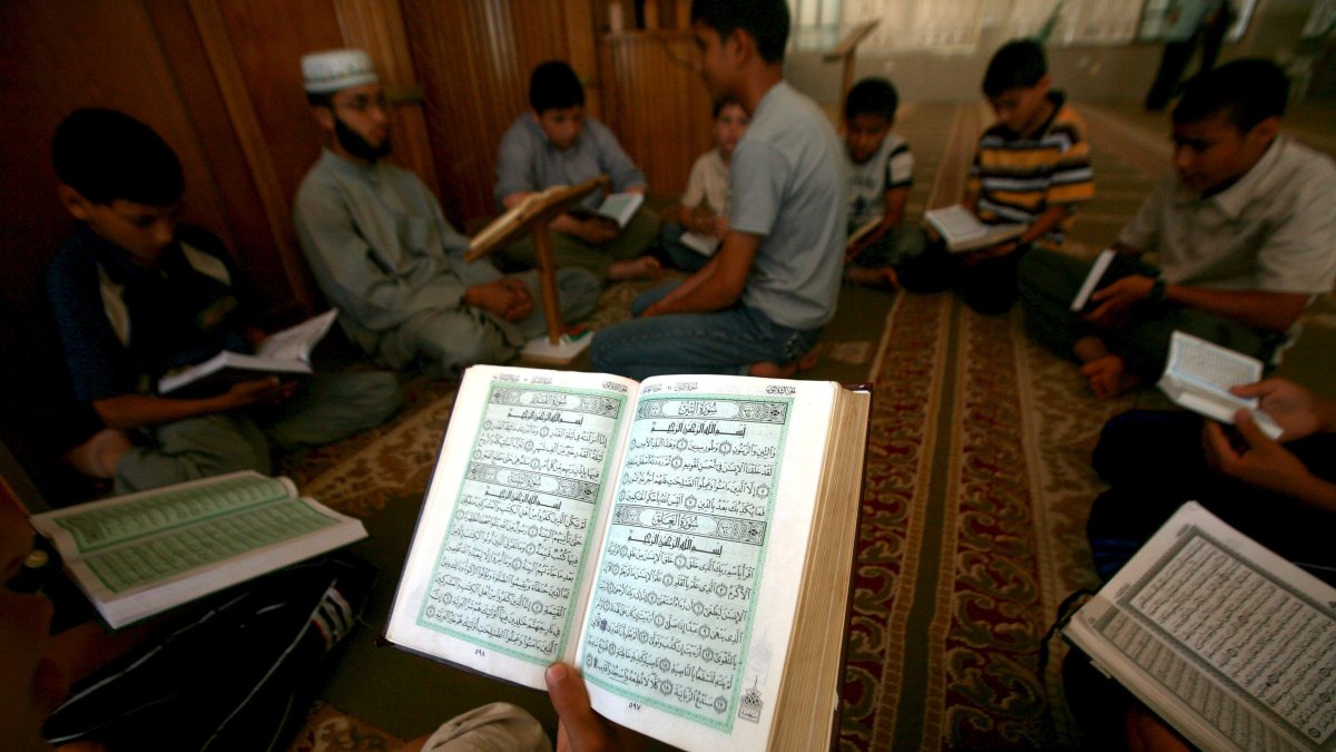 Gaza. Un grupo de niños palestinos se reúnen en algún lugar de la Franja para leer los versos del Coran ante la imposibilidad de asistir a clases.