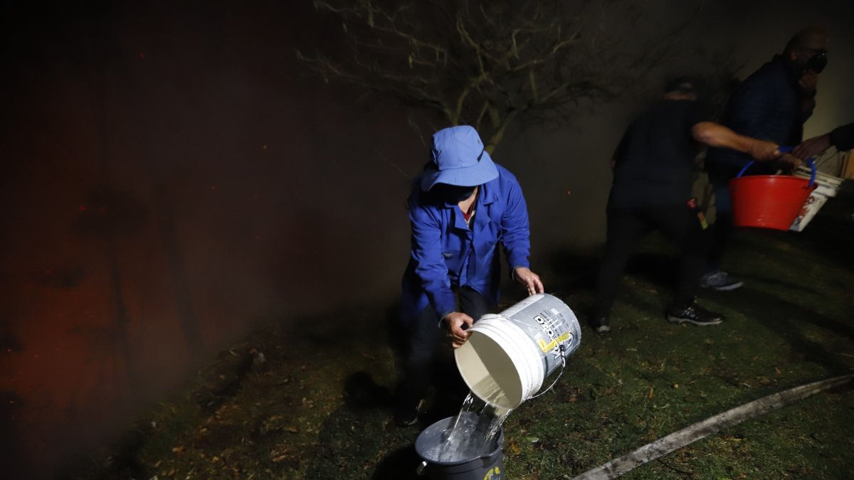 Intentos. Los quiteños hacen lo imposible para poder aplacar los focos de incendios cerca de sus casas.