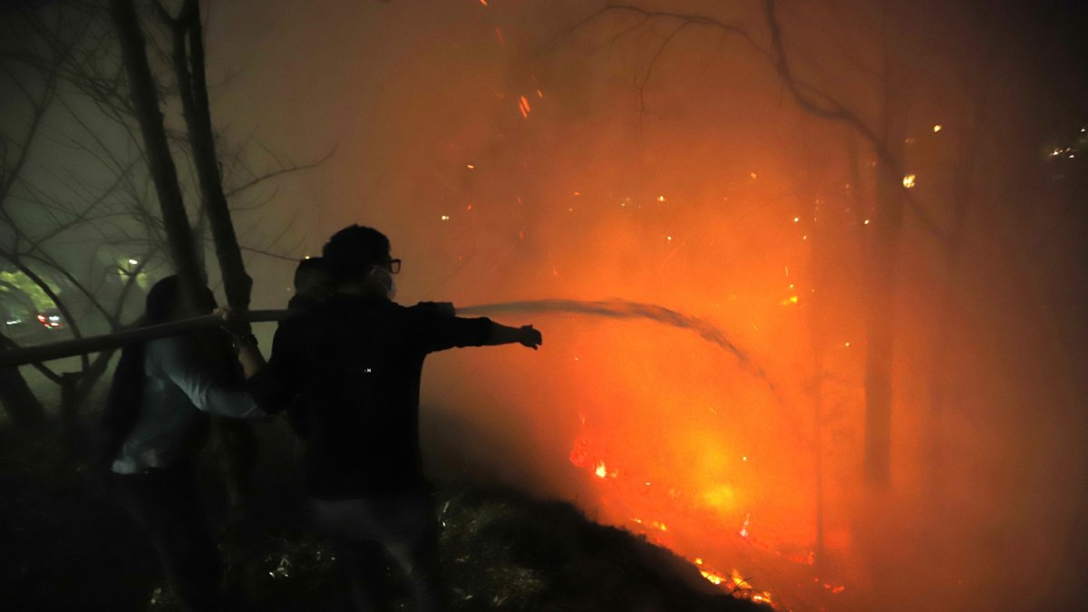 1. Guápulo. Con mangueras y baldes de agua, moradores de la zona ayudaban a los bomberos para evitar que el fuego llegue hasta las viviendas.
